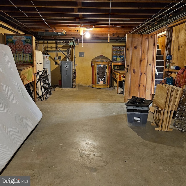 unfinished below grade area featuring water heater and a heating unit
