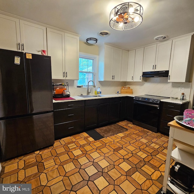 kitchen with freestanding refrigerator, electric stove, under cabinet range hood, a sink, and light countertops