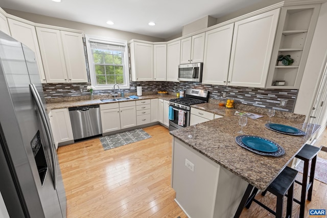 6348 Flintstone Dr, Barboursville, VA 22923 - kitchen featuring decorative backsplash, a peninsula, dark stone counters, a sink, and stainless steel appliances