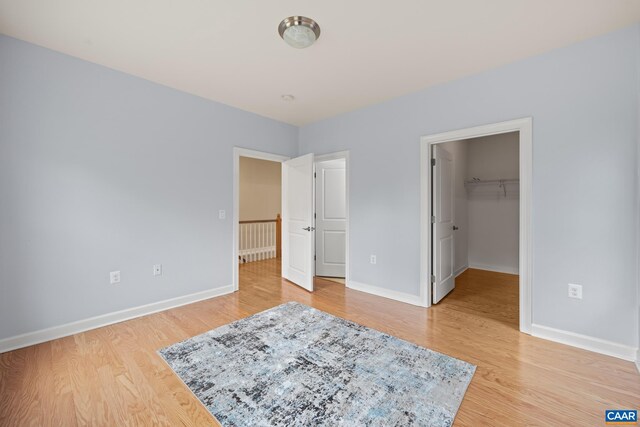 6348 Flintstone Dr, Barboursville, VA 22923 - unfurnished bedroom featuring baseboards, a walk in closet, and light wood-style floors