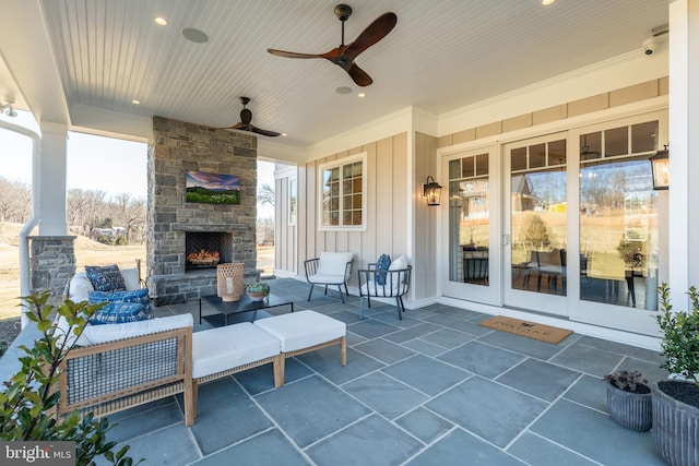 view of patio featuring a ceiling fan and an outdoor stone fireplace