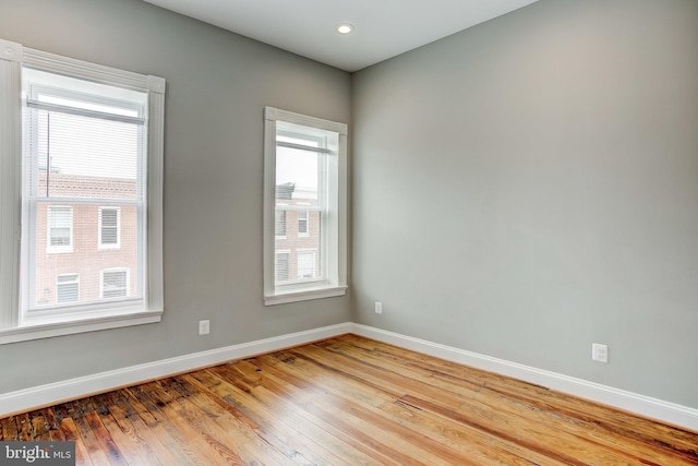 spare room featuring baseboards and hardwood / wood-style flooring