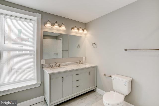 full bathroom featuring a sink, toilet, baseboards, and marble finish floor