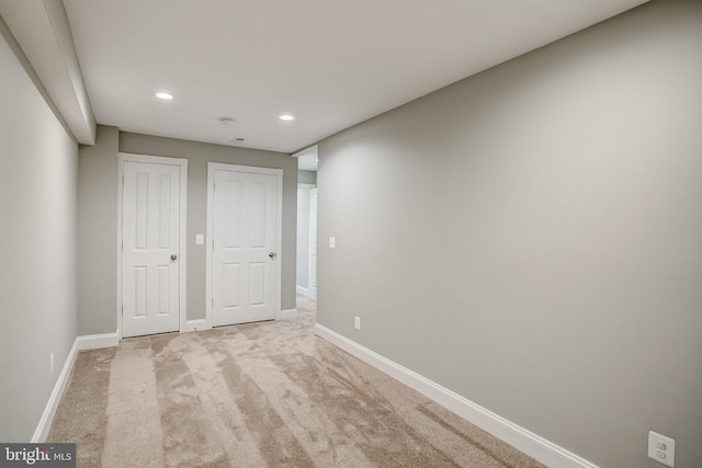 unfurnished bedroom with carpet, two closets, baseboards, and recessed lighting