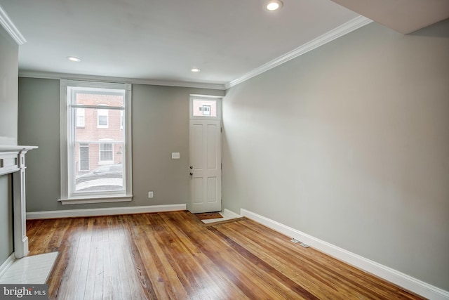 unfurnished living room with hardwood / wood-style floors, crown molding, visible vents, baseboards, and recessed lighting