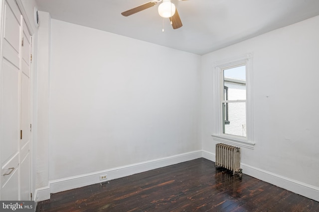 unfurnished room with baseboards, ceiling fan, radiator heating unit, and dark wood-type flooring