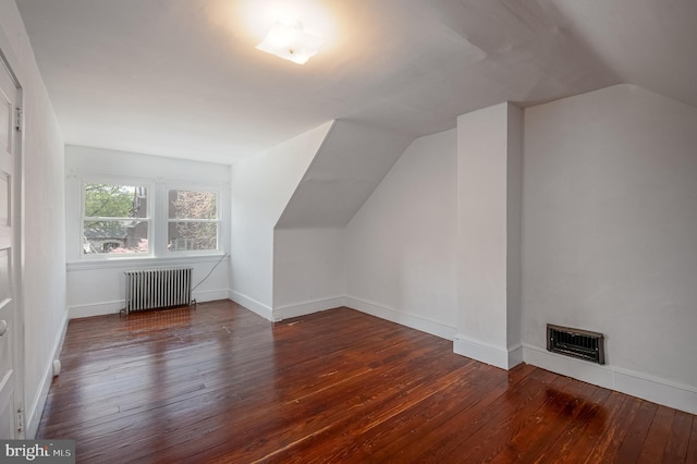 bonus room featuring wood-type flooring, visible vents, radiator heating unit, baseboards, and lofted ceiling