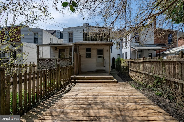 back of house featuring a wooden deck and a fenced backyard