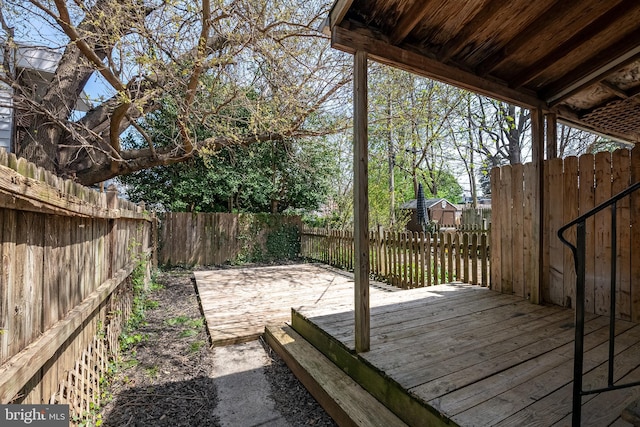 deck with a storage shed, an outdoor structure, and a fenced backyard