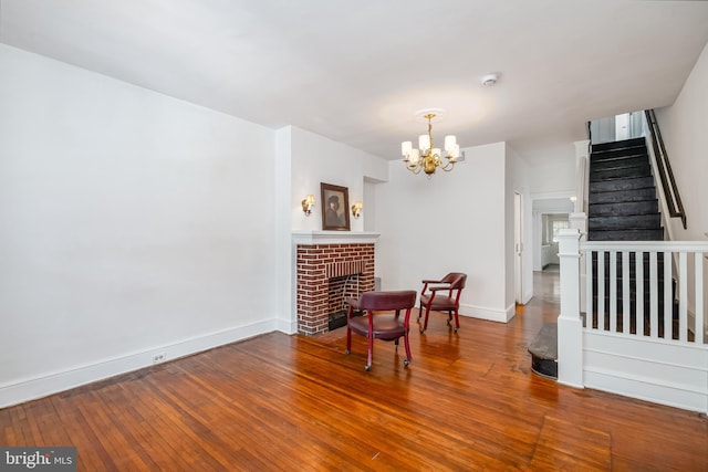 dining space with stairway, a fireplace, a notable chandelier, baseboards, and hardwood / wood-style flooring