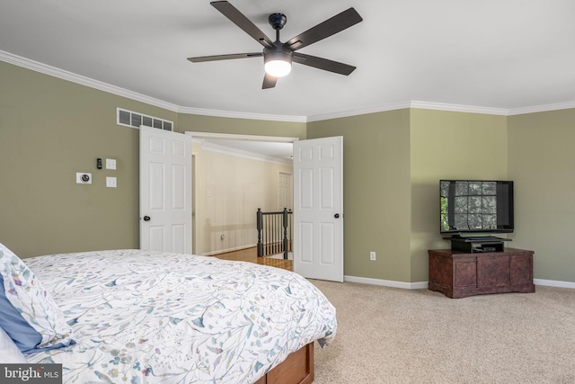 bedroom with baseboards, visible vents, ornamental molding, and light carpet