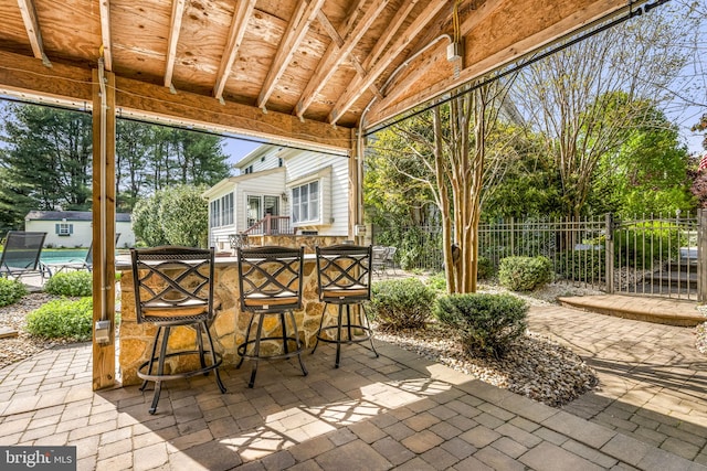 view of patio / terrace with fence, an outbuilding, and outdoor dry bar