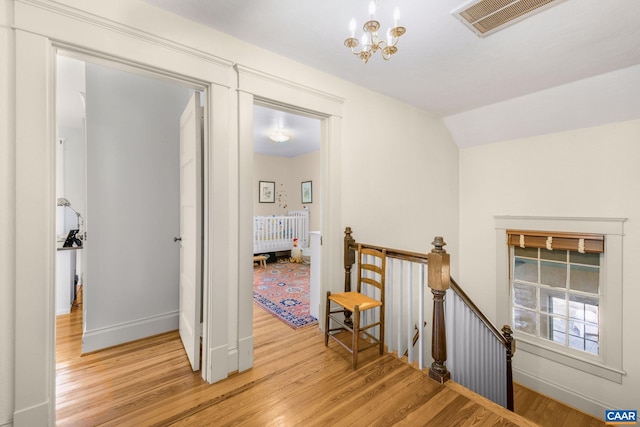 2616 Jefferson Park Cir, Charlottesville, VA 22903 - corridor featuring baseboards, an inviting chandelier, visible vents, light wood-style floors, and an upstairs landing
