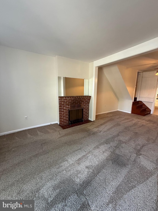 427 S Market St, Frederick, MD 21701 - unfurnished living room featuring carpet, a brick fireplace, baseboards, and stairway