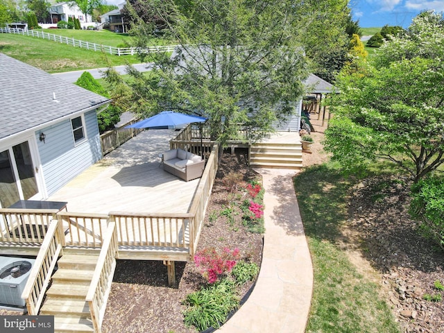 view of yard featuring fence, a wooden deck, and stairs