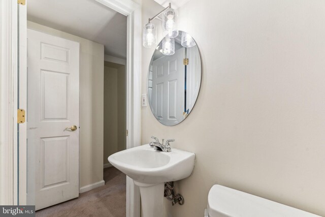 half bath with baseboards and toilet