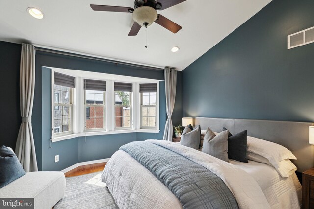 bedroom with recessed lighting, vaulted ceiling, visible vents, and wood finished floors