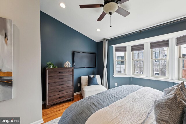 bedroom featuring lofted ceiling, wood finished floors, recessed lighting, and multiple windows