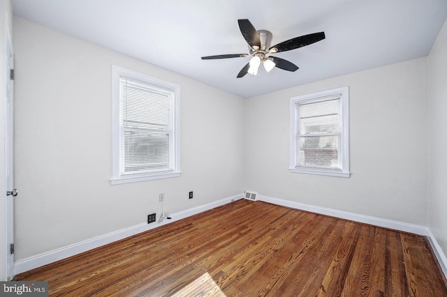 empty room featuring baseboards, a ceiling fan, wood finished floors, and visible vents