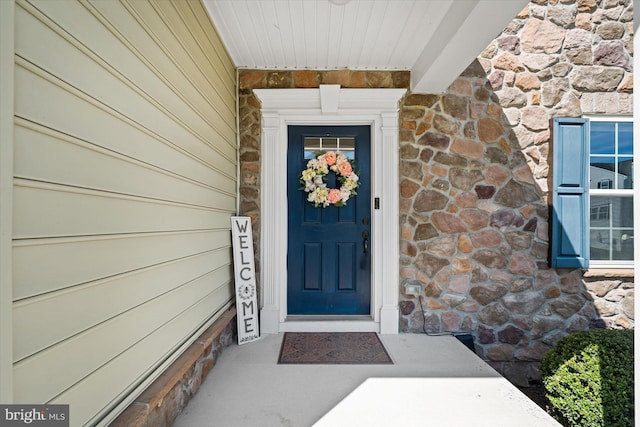 doorway to property featuring stone siding