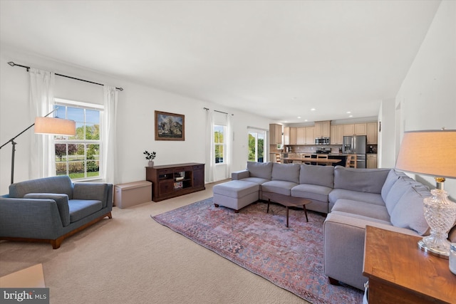 living room featuring recessed lighting, a wealth of natural light, and light carpet