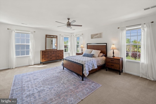 carpeted bedroom featuring baseboards, visible vents, and ceiling fan