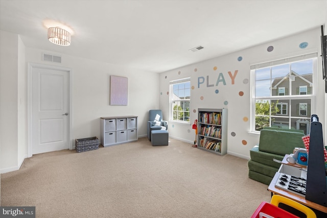 recreation room with carpet floors, visible vents, and baseboards