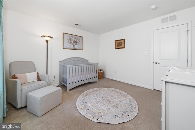 bedroom with a nursery area, carpet floors, visible vents, and baseboards