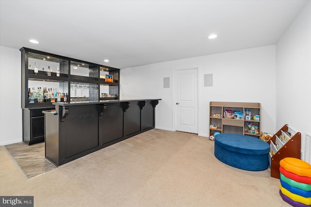bar featuring baseboards, recessed lighting, light colored carpet, and wet bar