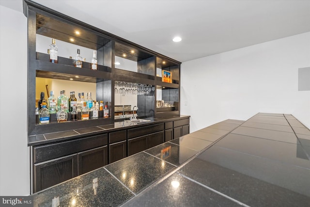 bar with recessed lighting, a bar, and a sink