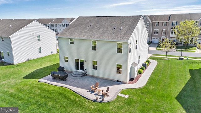 rear view of property with a residential view, roof with shingles, central AC, a patio area, and a yard
