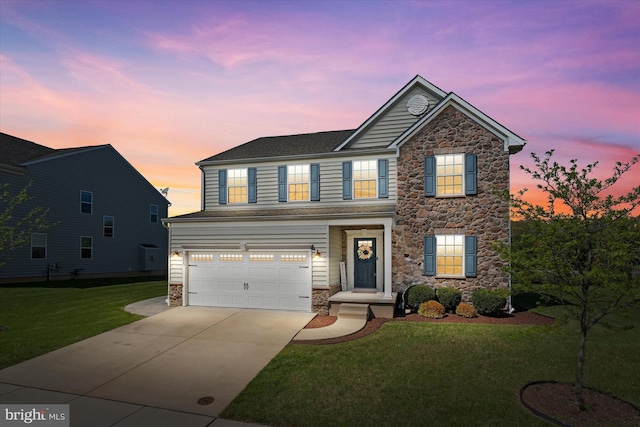 traditional home featuring concrete driveway, a yard, stone siding, and a garage