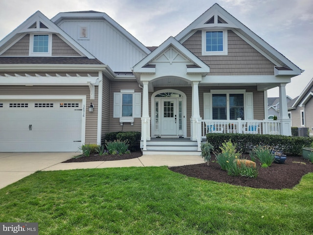 craftsman house featuring driveway, a front yard, a porch, and central air condition unit