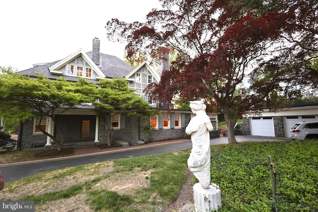 2203 N Grant Ave, Wilmington, DE 19806 - view of front facade featuring driveway, a chimney, stone siding, and a garage