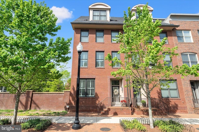 view of front of house with brick siding and fence