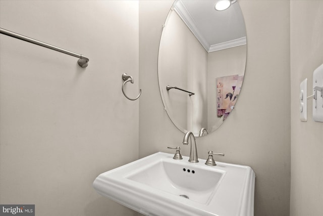 bathroom featuring ornamental molding and a sink