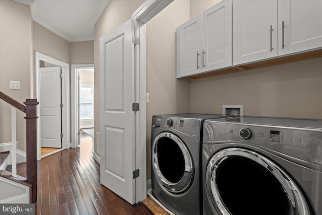 laundry area with cabinet space, dark wood-style floors, ornamental molding, and washer and clothes dryer