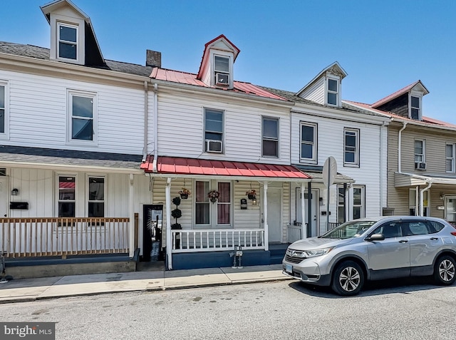 townhome / multi-family property featuring covered porch and metal roof