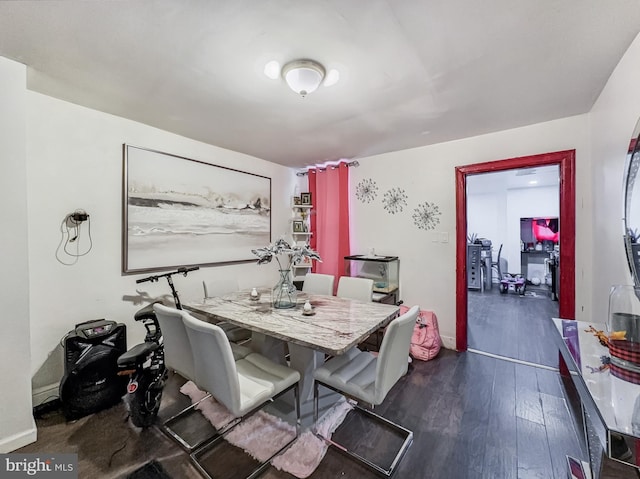 dining area with dark wood-style flooring and baseboards