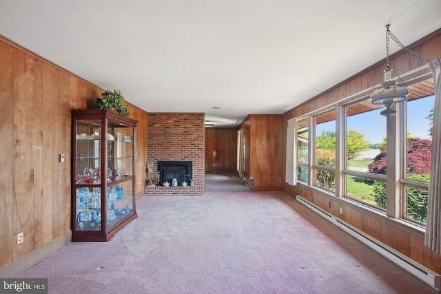 5537 Eldorado Sharptown Rd, Rhodesdale, MD 21659 - unfurnished living room featuring a baseboard radiator, wooden walls, carpet floors, a brick fireplace, and baseboards