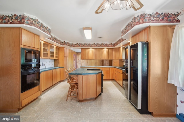 5537 Eldorado Sharptown Rd, Rhodesdale, MD 21659 - kitchen featuring black appliances, ceiling fan, a kitchen bar, glass insert cabinets, and a kitchen island