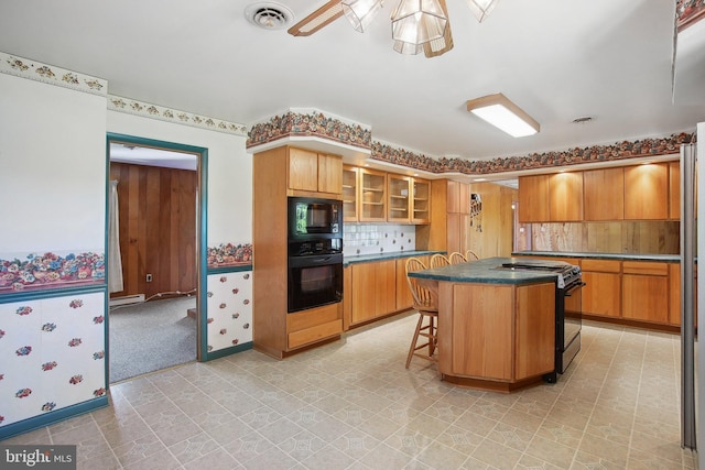 5537 Eldorado Sharptown Rd, Rhodesdale, MD 21659 - kitchen with black appliances, a ceiling fan, a breakfast bar, glass insert cabinets, and a kitchen island