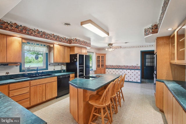 5537 Eldorado Sharptown Rd, Rhodesdale, MD 21659 - kitchen featuring black appliances, dark countertops, a kitchen bar, a center island, and wallpapered walls