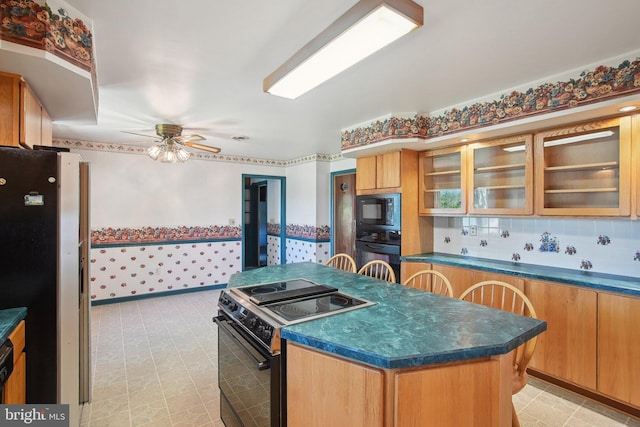 5537 Eldorado Sharptown Rd, Rhodesdale, MD 21659 - kitchen featuring black appliances, a center island, dark countertops, a ceiling fan, and glass insert cabinets