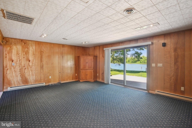 5537 Eldorado Sharptown Rd, Rhodesdale, MD 21659 - empty room featuring a baseboard heating unit, dark carpet, wooden walls, and a water view