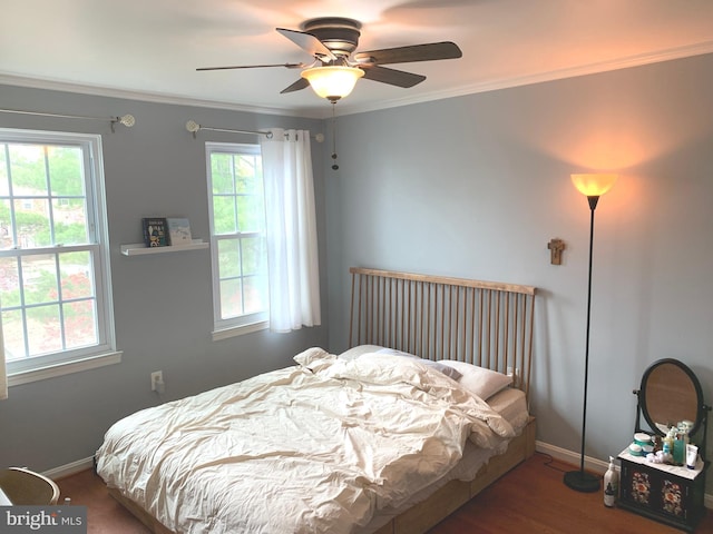 bedroom with crown molding, a ceiling fan, wood finished floors, and baseboards