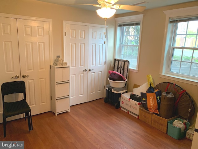 living area featuring light wood-type flooring, a ceiling fan, visible vents, and a healthy amount of sunlight