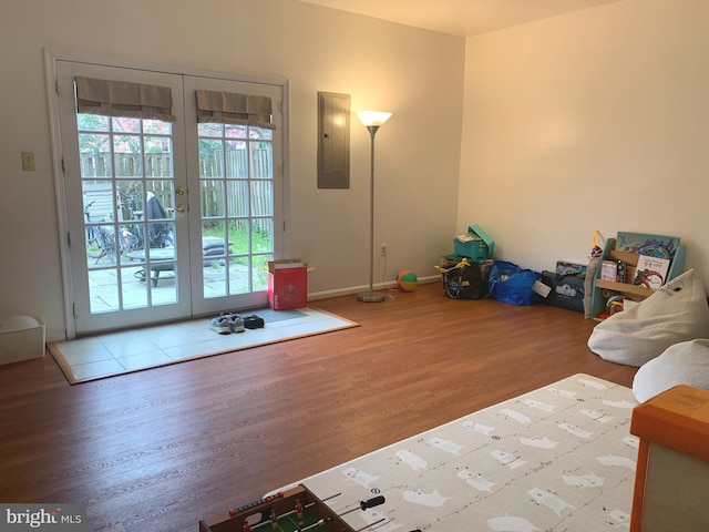 unfurnished living room featuring wood finished floors, french doors, and electric panel