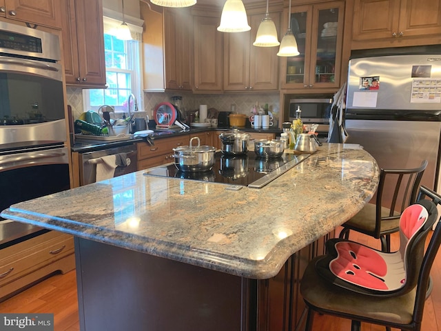 kitchen with tasteful backsplash, a kitchen bar, stainless steel appliances, and a center island