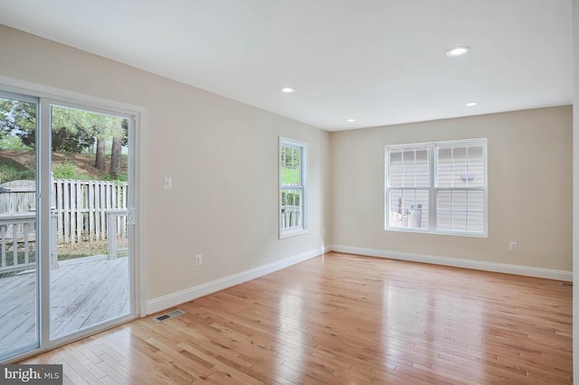 unfurnished room with recessed lighting, baseboards, light wood-type flooring, and visible vents